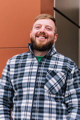 Fototapeta premium Happy bearded man. Portrait of a cheerful casual man in plaid shirt
