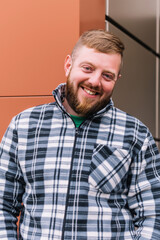 Fototapeta premium Happy bearded man. Portrait of a cheerful casual man in plaid shirt