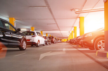 Guarded multilevel car parking in the shopping center, sunset. Copy space for text