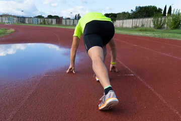 A man in position to start running.