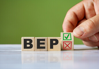 hand turn wooden block with red reject X and green confirm tick as change concept of BEP. Word BEP conceptual symbol.