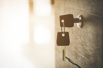 close up of key on wooden cabinet with blurred background and copy space.