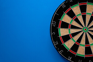 target dart board on the blue table background, center point, head to target marketing and business...