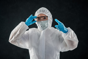 Professional cleaning staff with a To wear protective medical mask and PPE suit use a chemical...