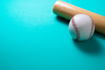 baseball and baseball bat on green table background, close up