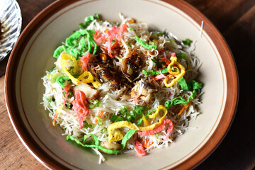 Fried noodle ( rice vermicelli ) in a plate with soy sauce on a wooden table. Popular asian food