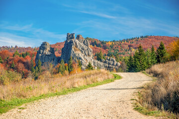 Winding dirt road to Tustan fortress in Carpathian Mountains, Ukraine at sunny autumn day