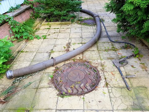 A Hose For Pumping Water From The Well Is Lowered Into The Hatch. The Slurry Pump Machine Pumps Dirty Water.