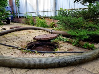 Image of the courtyard of a private house where a sewer well is pumped out. Septic tank outside the gate