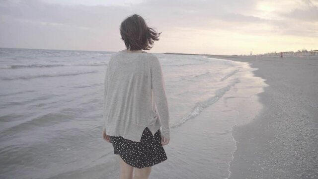 Beautiful happy Woman walking in the water on the beach towards sunset, 1080p 50fps slog 2