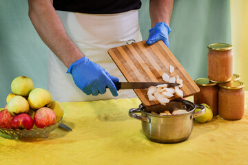 Man cuts off the peel of an apple. Conservation. Cooking apples. Saving apples for the winter.