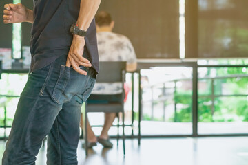 Left Hand of man taking money from his own pocket to pay for drinks in a coffee shop. Selective focus