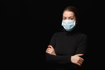 Young woman in a medical mask on a black background. Young woman in a medical mask on a black...