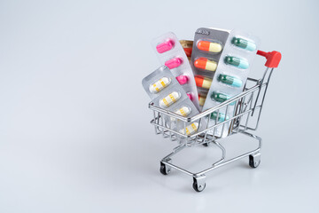 Medicine, vitamins and antioxidant supplements in trolley on white background