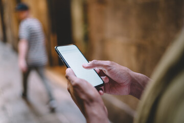 Crop person using smartphone on street