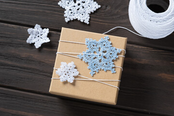Fototapeta na wymiar Idea gifts wrapping of the Christmas gift and decoration with knitted snowflakes.