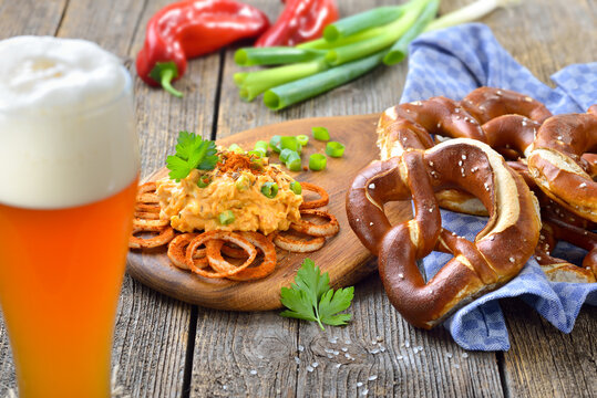 Deftiger Obazda mit frischen, bayerischen Brezen vom B&auml;ckermeister dazu ein k&uuml;hles Hefewei&szlig;bier &ndash; Bavarian cheese speciality with fresh pretzels from the domestic master baker served with a wheat beer
