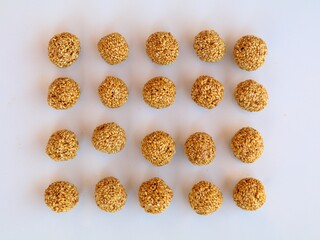 White sesame seed balls made with heated  jiggery against white background