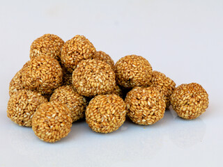 White sesame seed balls made with heated  jiggery against white background