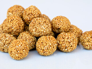 White sesame seed balls made with heated  jiggery against white background