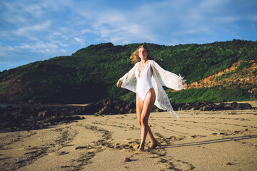 Smiling female dancing on sand