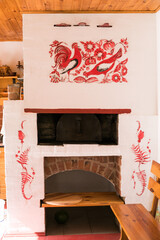 Russian oven, traditional furnace for rural kitchen. Vintage stove with firewood and floral decor.