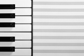 Empty musical sheet with piano keyboard from the left side, black and white musical background with...