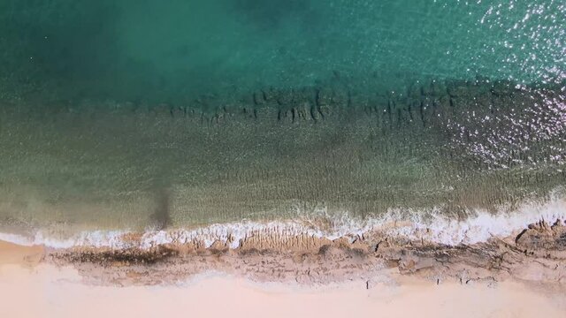 Overhead drone clp of waves crushing to the shore in Kavala, Macedonia, Greece