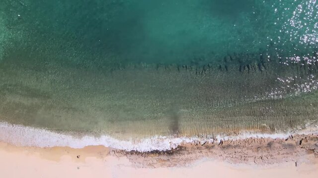 Overhead drone clp of waves crushing to the shore in Kavala, Macedonia, Greece