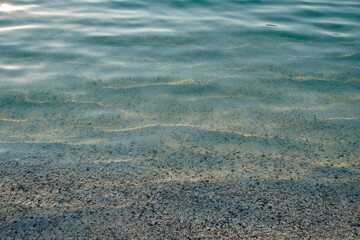 Atlantic Ocean coast with colorful stones of emerald water shells