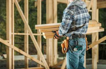 Construction Worker Moving Wood Material