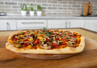Still life. Freshly baked pizza on a wooden board. Vegan food.