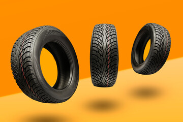 three winter tires friction Velcro on a bright orange background. seasonal change of wheels for winter - obrazy, fototapety, plakaty