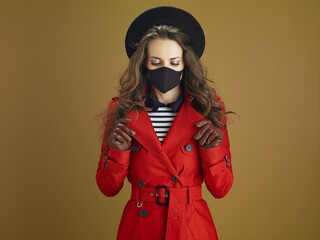 Fototapeta premium relaxed modern woman in red coat on bronze background