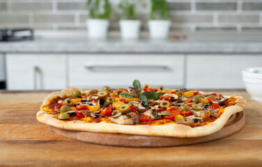 Still life. Freshly baked pizza on a wooden board. Vegan food.
