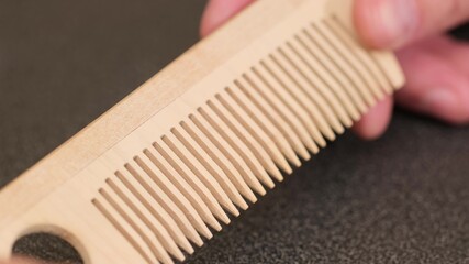 Thin comb of light wood on a white background. close up