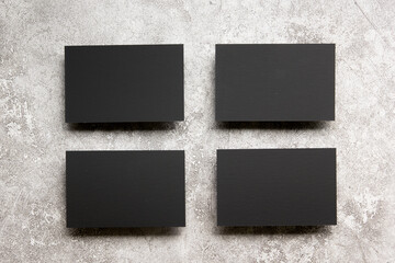 Fototapeta premium Black business cards blank on textured background. Identity design, corporate templates, company style. Flat lay