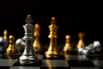 Silver King chess standing in front of other chess, Concept of a leader must have courage and challenge in the competition, leadership and business vision for a win in business games