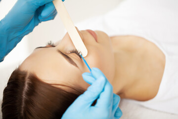 Eyelash Extension Procedure, Professional stylist lengthening female lashes.