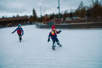 Fototapeta na wymiar boy and girl skating together in winter