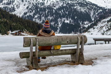 Femme sur un banc admirant le paysage montagneux