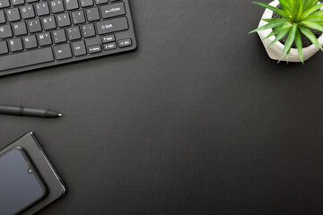 Black desk office with laptop, smartphone and other work supplies with cup of coffee. Top view with copy space for input the text. Designer workspace on desk table essential elements on flat lay