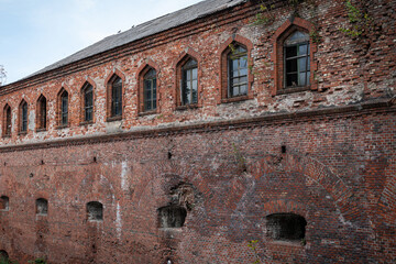 Fototapeta premium An old abandoned building. Collapsing walls and windows. Deserted and forgotten house. Former defensive building.