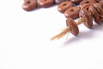 Wooden beads with natural jute string Twine Rope on white background. Close up, macro.