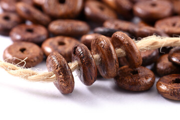 Wooden beads with natural jute string Twine Rope on white background. Close up, macro.