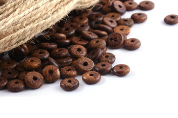 Wooden beads with natural jute string Twine Rope on white background. Close up, macro.