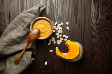 Pumpkin soup with pumpkin seeds on wooden table