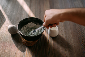 Face and body care. Preparation of a cosmetic mask in a bowl on a table