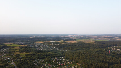 Beautiful top view of the forest and suburb with houses and a park