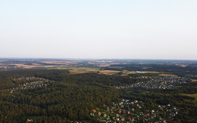 Beautiful top view of the forest and suburb with houses and a park